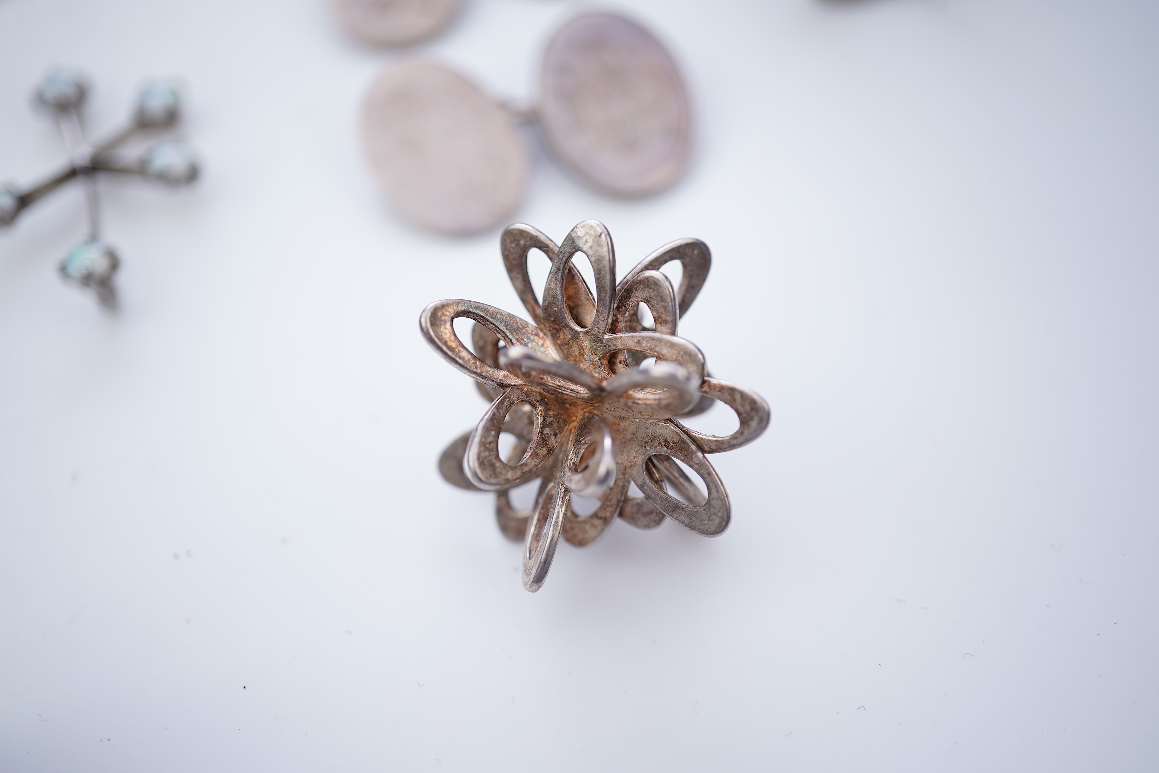 A collection of silver jewels, comprising: a bangle; a chain necklace suspending two winding toothpicks, one with toothpick deficient; a rope twist chain; a pair of cufflinks with the initials DBH; a pendant of abstract